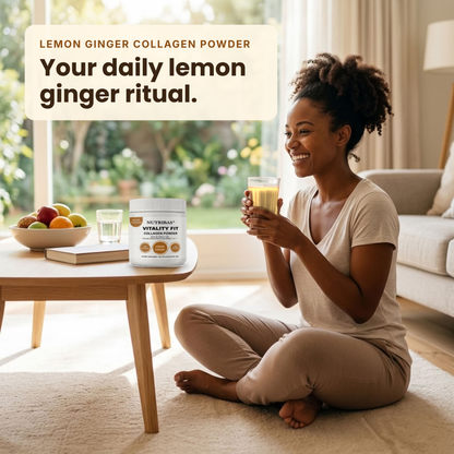 A woman sits cross-legged on a beige carpet in a bright living room, holding a glass of yellow drink. On the table beside her is a white tub labeled 'NutriBlast Vitality Fit' and 'Lemon Ginger Collagen Powder,' along with a bowl of fruit and a glass.