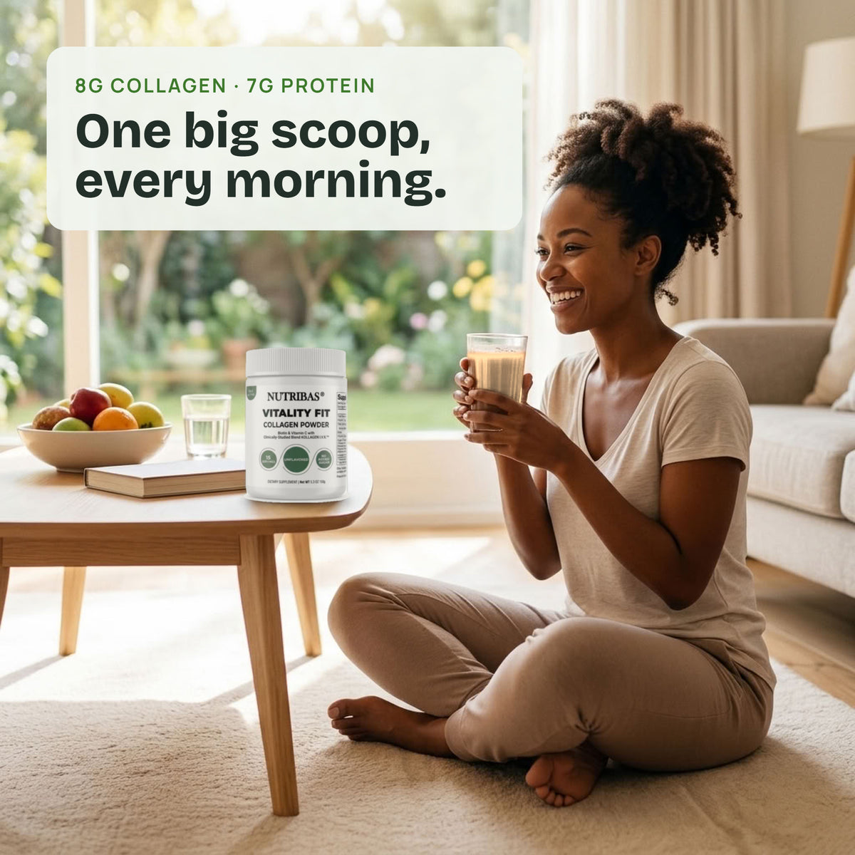 A woman sits cross-legged on a beige rug in a bright living room, holding a glass of milk-based drink. A white supplement tub labeled NutriBio Vitality Pro with 8G Collagen and 7G Protein is placed on a wooden coffee table nearby.